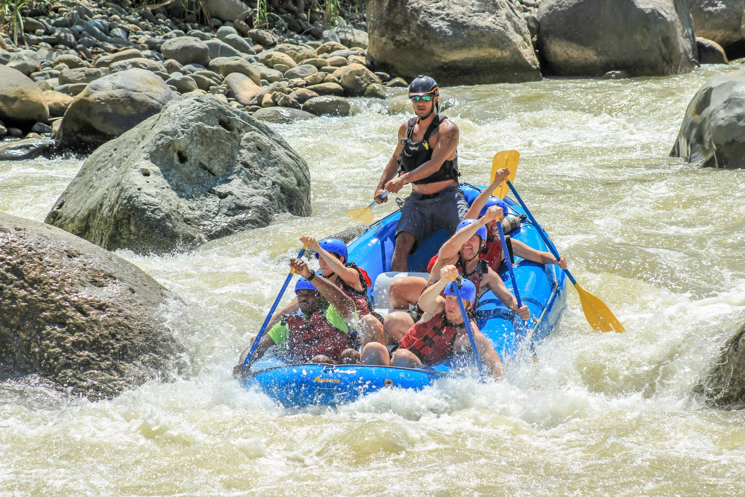 A raft dropping through a boulder rapid