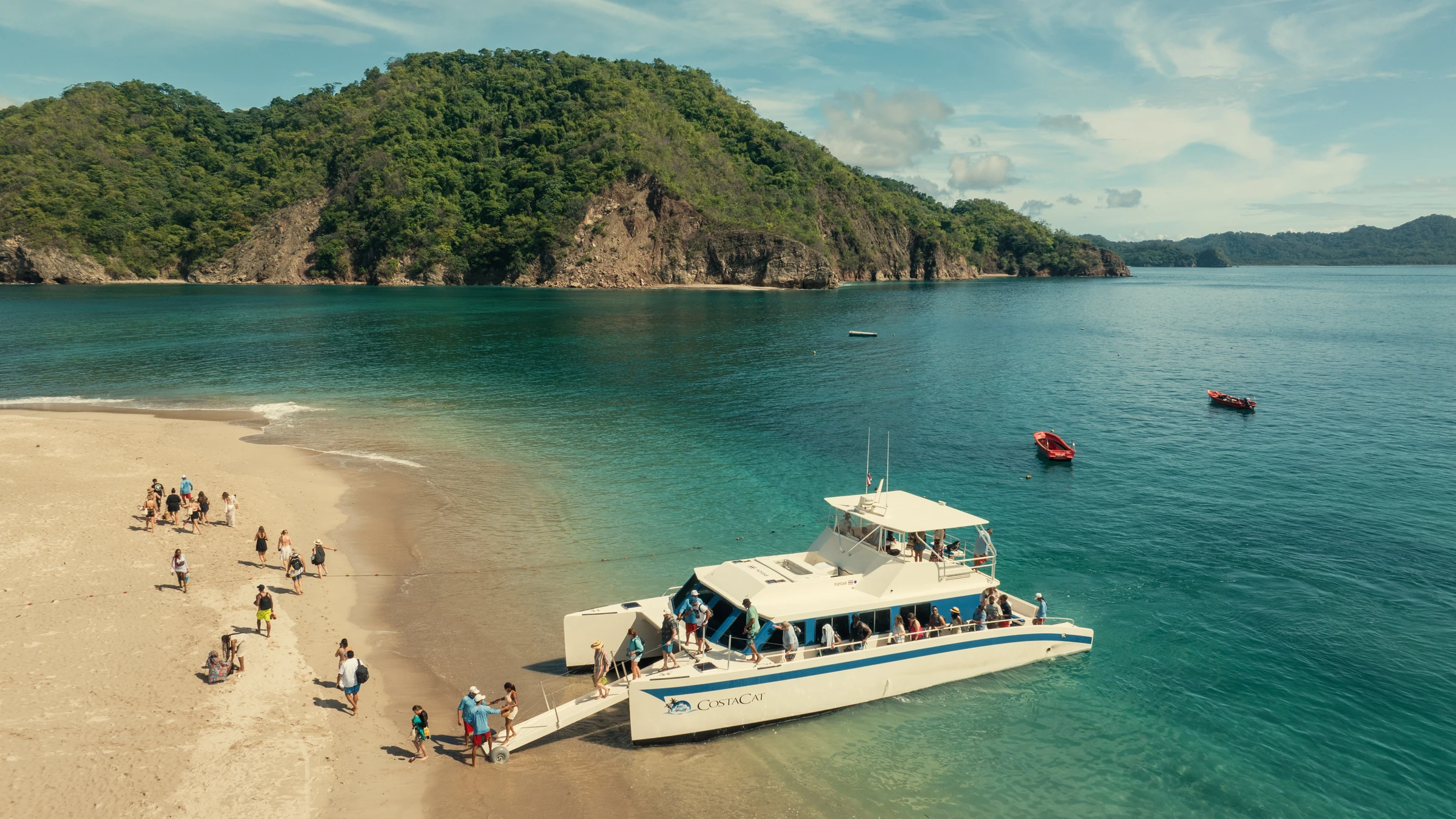 A catamaran anchored off a white-sand beach at Tortuga Island