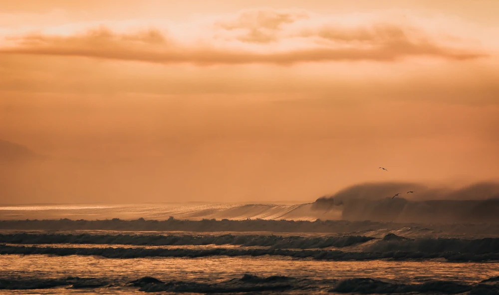 Orange dawn light over the Pacific coastline