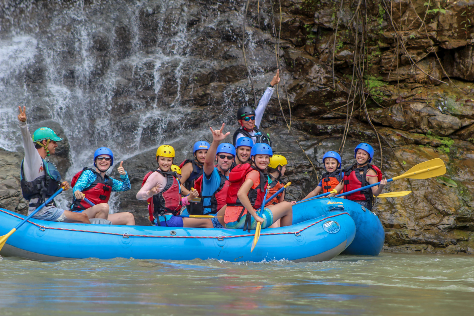 Families rafting past a jungle waterfall on the Savegre river