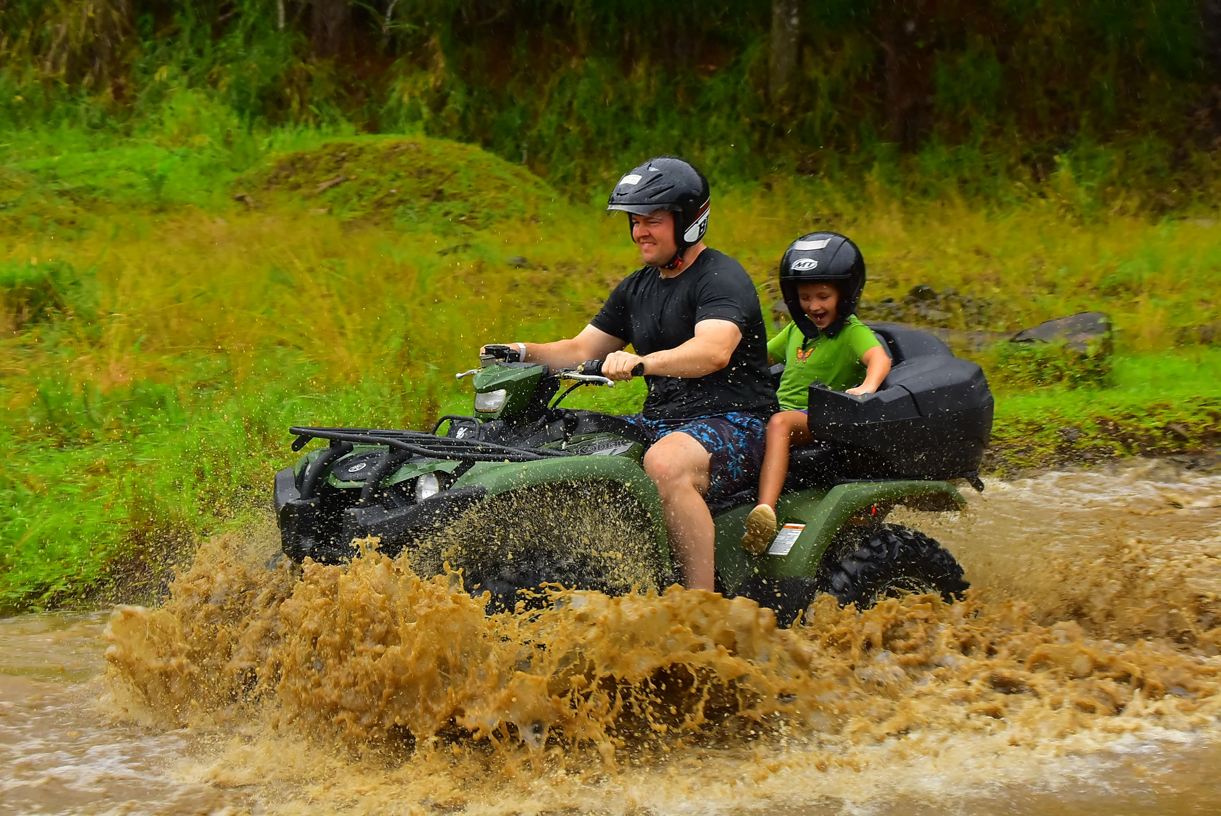 An ATV splashing through mud