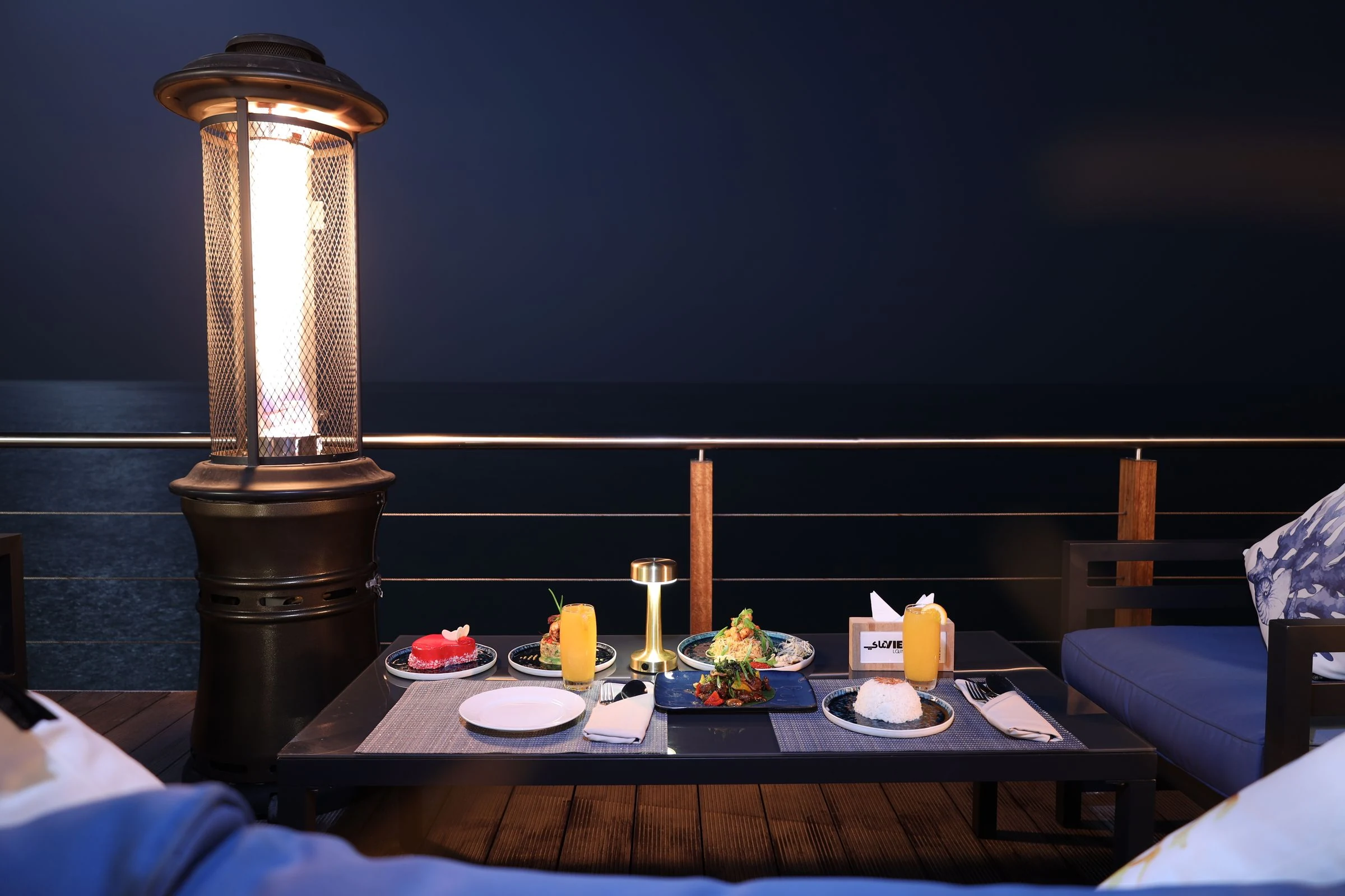 Lantern-lit dinner table set on a terrace at night