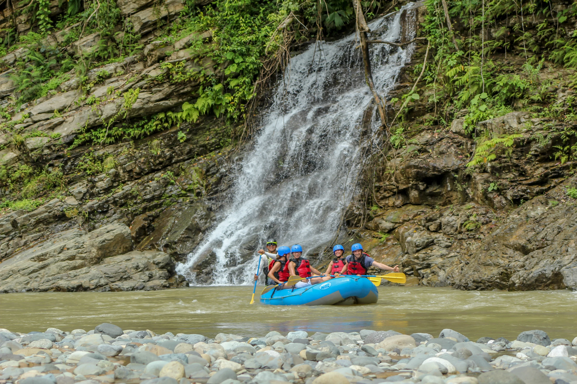 Rafts passing a jungle waterfall on the river