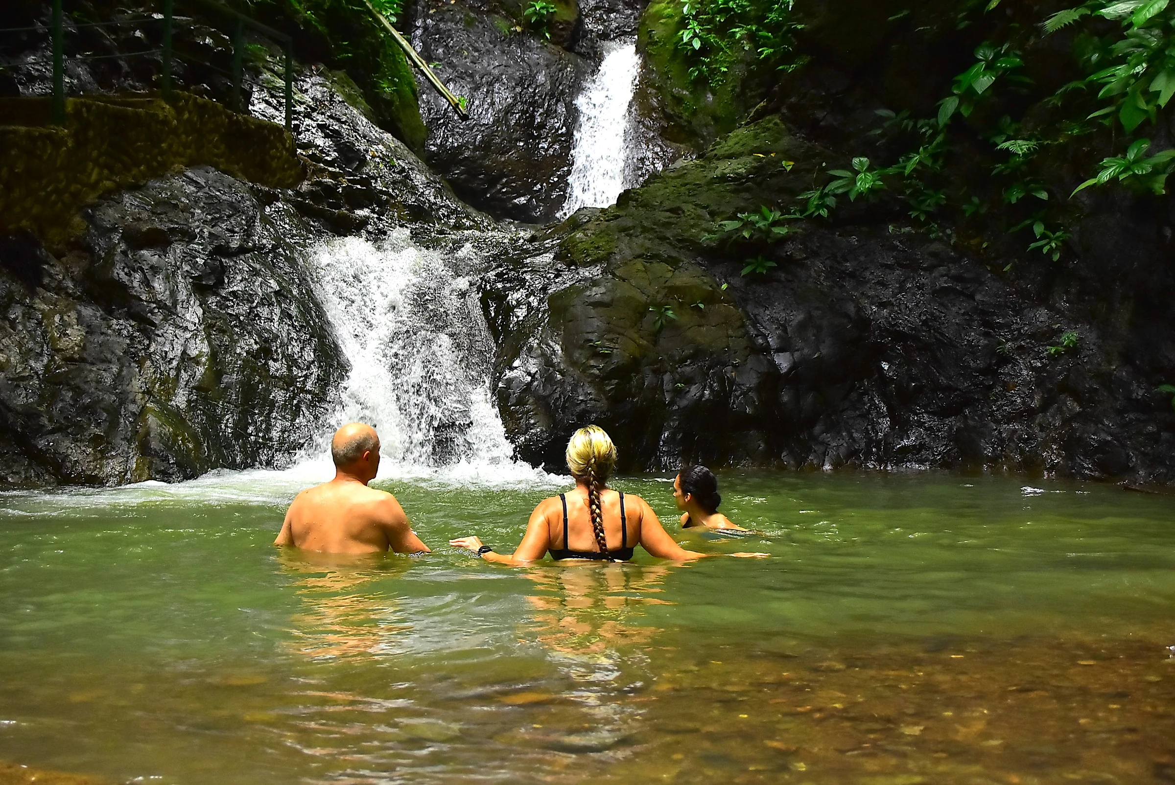 Swimmers in a waterfall pool