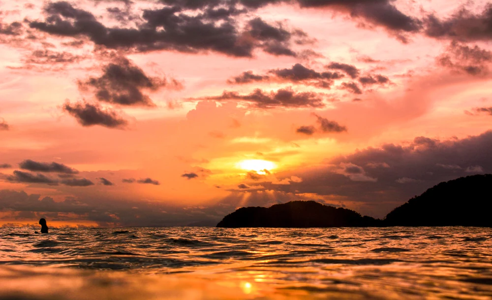A paddle boarder at sunset