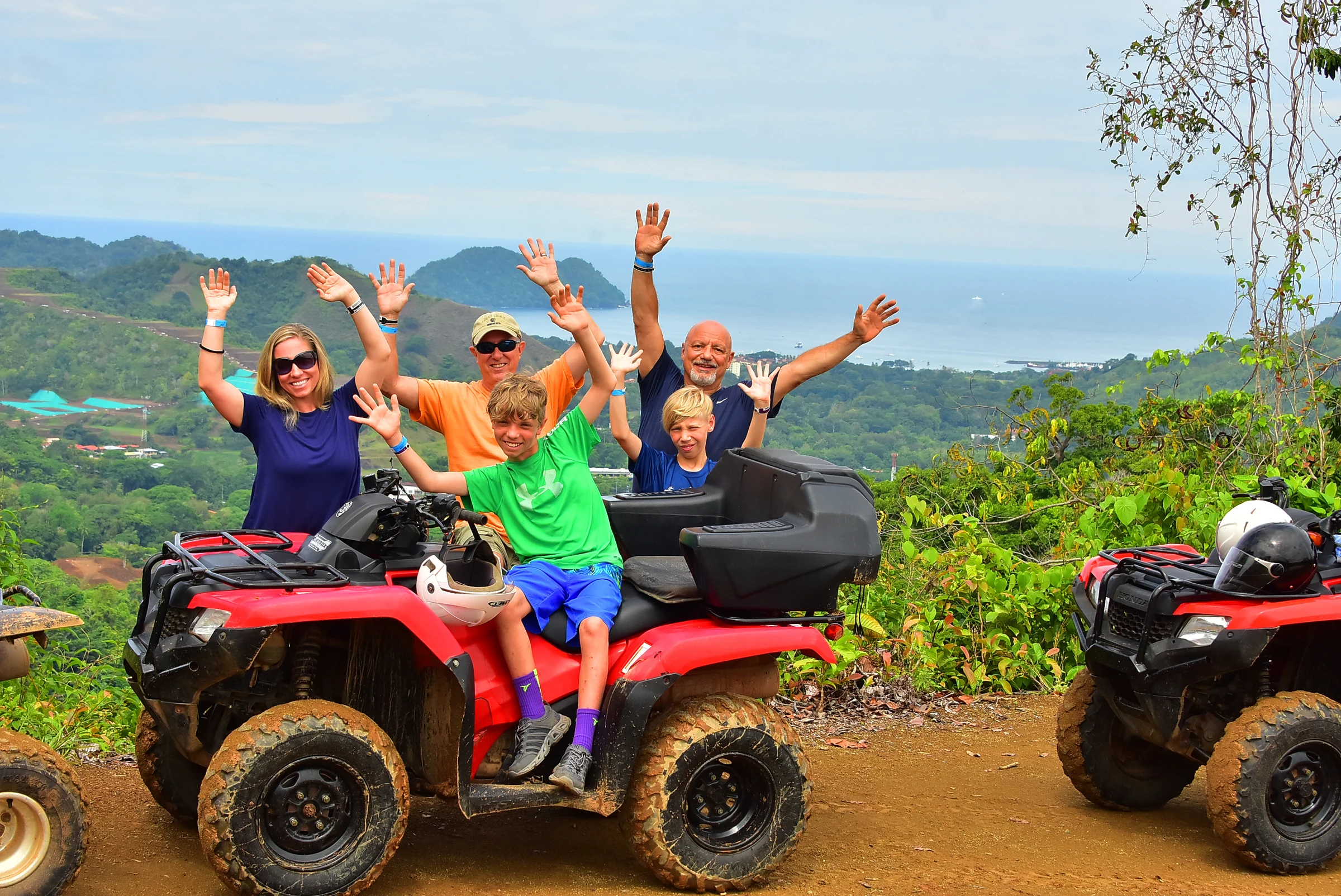 A group cheering beside their ATVs