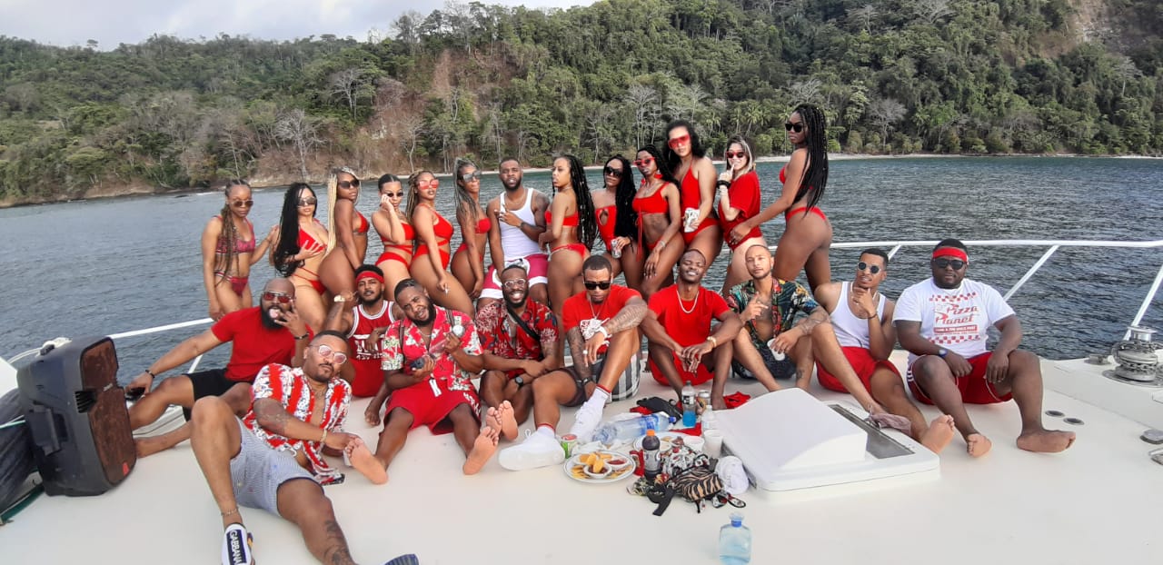 A large group of friends posing together on the deck of a private charter